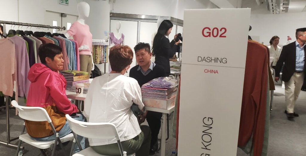 A group of people sitting at a table in a clothing store.